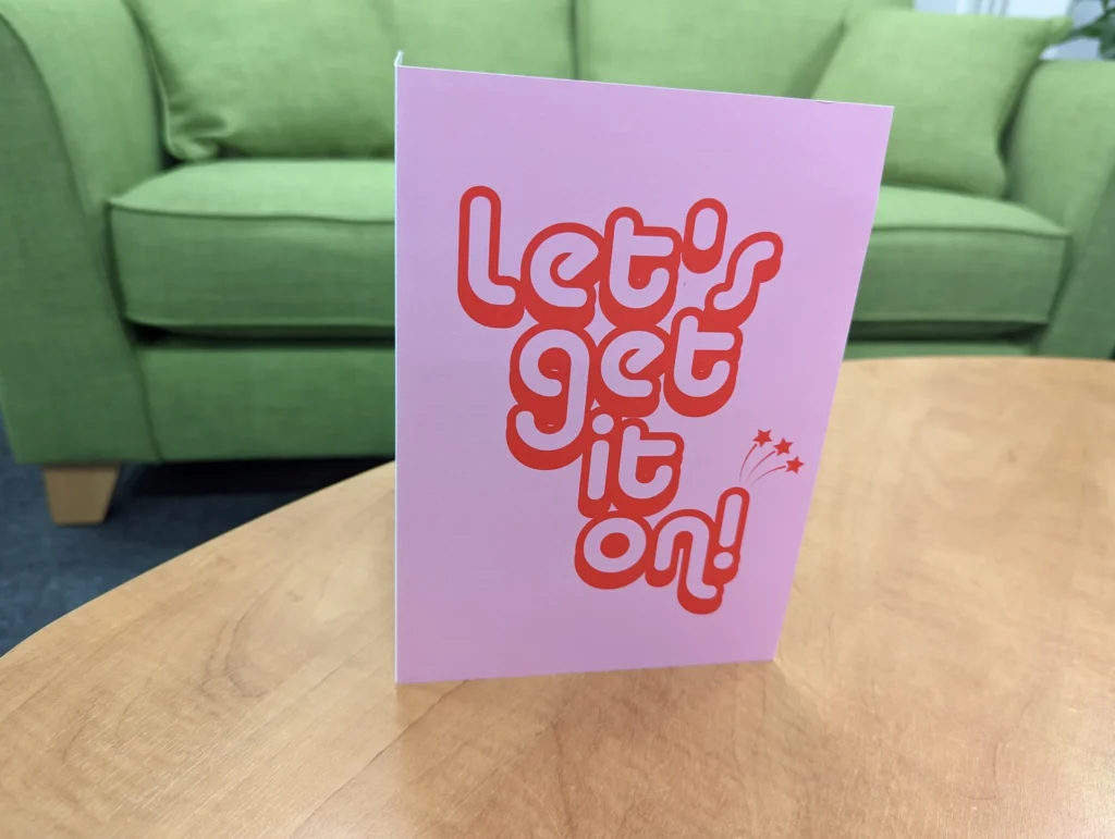 A pink valentines day card with red text saying "Let's get it on!"